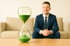 <img src="..." alt="Mann im Anzug mit Sanduhr symbolisiert schnelle Rückmeldung im Tarifvergleich">