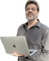 Ein Mann mit Bart und Brille hält ein offenes graues MacBook.