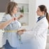 A doctor checks a smiling woman's waist for weight management.
