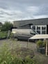 Mercedes Sprinter Camper mit geöffnetem Aufstelldach auf Firmengelände – individueller Reisemobil-Ausbau in professioneller Manufaktur-Umgebung