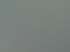 Lächelnder Mann in blauem Sakko und weißem Hemd lehnt an einem Schreibtisch in einem hellen, modernen Büro.