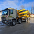 Ein Mercedes-Benz Betonmischer mit gelb-schwarzer Trommel, auf der "Heimerdinger Härig" steht, parkt auf einer Fläche.