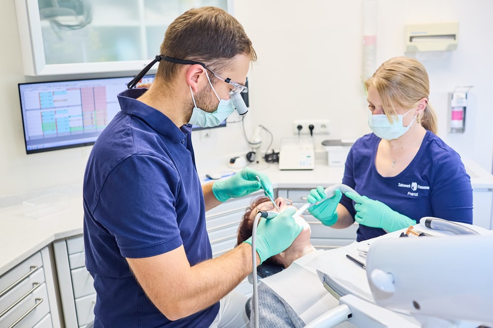 Zahnarzt und Assistentin bei der Behandlung