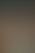 Eine Person filmt eine Bühne mit einem goldenen Smartphone; das Display zeigt eine Darbietung mit Lichtern.