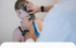 Michael Horn fixiert ein Kinesio-Tape auf die Schulter einer Patientin