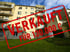 Mehrfamilienhaus mit rotem Stempel "VERKAUFT FÜR 130.000 €" über Vorderseite und Rasen.