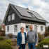 Paar steht vor einem Haus mit Solaranlage auf dem Dach.