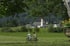Zwei Radfahrer auf Fahrrädern auf einem Feldweg mit einem Dorf und einer Kirche im Hintergrund.