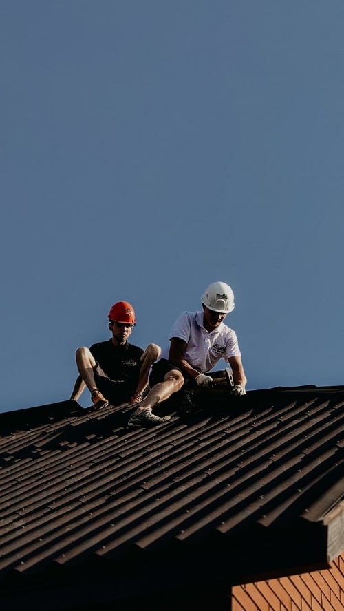 Two contractors repairing a roof