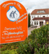 Oranges Schild der Senioren-WG Rothenburgblick in Kelbra vor einem weißen Wohngebäude mit Garten.
