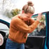 Woman experiencing neck pain after auto accident, possible whiplash while exiting car