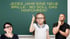 Zu sehen ist eine Schultafel. Davor stehen eine Mutter (links) und ein Vater (rechts). Dazwischen die kleine Tochter mit mahmendem Zeigefinger, der zur Aufschrift führt: "Jedes Jahr eine neue Brille - Wo soll das hinführen?"