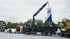 Ein LKW mit Kran hält ein Banner der Firma JUNO hoch, daneben stehen eine Hüpfburg und eine Dartscheibe im Freien.