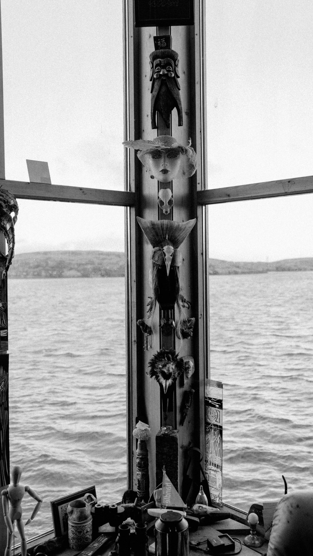 Schnitzsäule am Fenster mit Blick aufs Wasser, Schwarz-Weiß