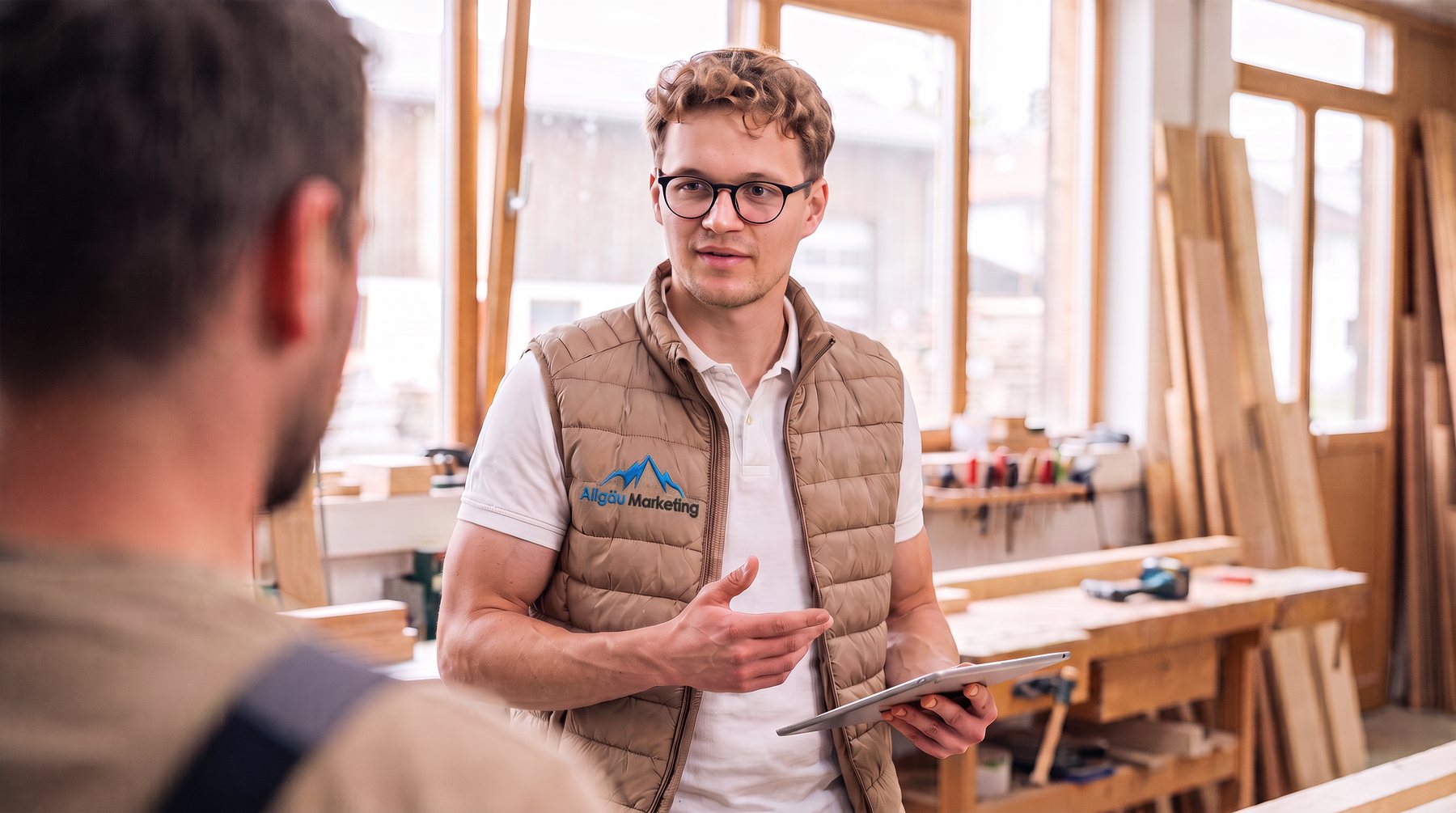Oliver Schönemann von Allgäu Marketing im Gespräch mit einem Handwerker in der Werkstatt