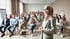 Frau im Hijab spricht vor Publikum in einem Konferenzraum.