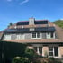 Wohnhaus mit Solarmodulen auf dem Dach und Gerüst an der Fassade