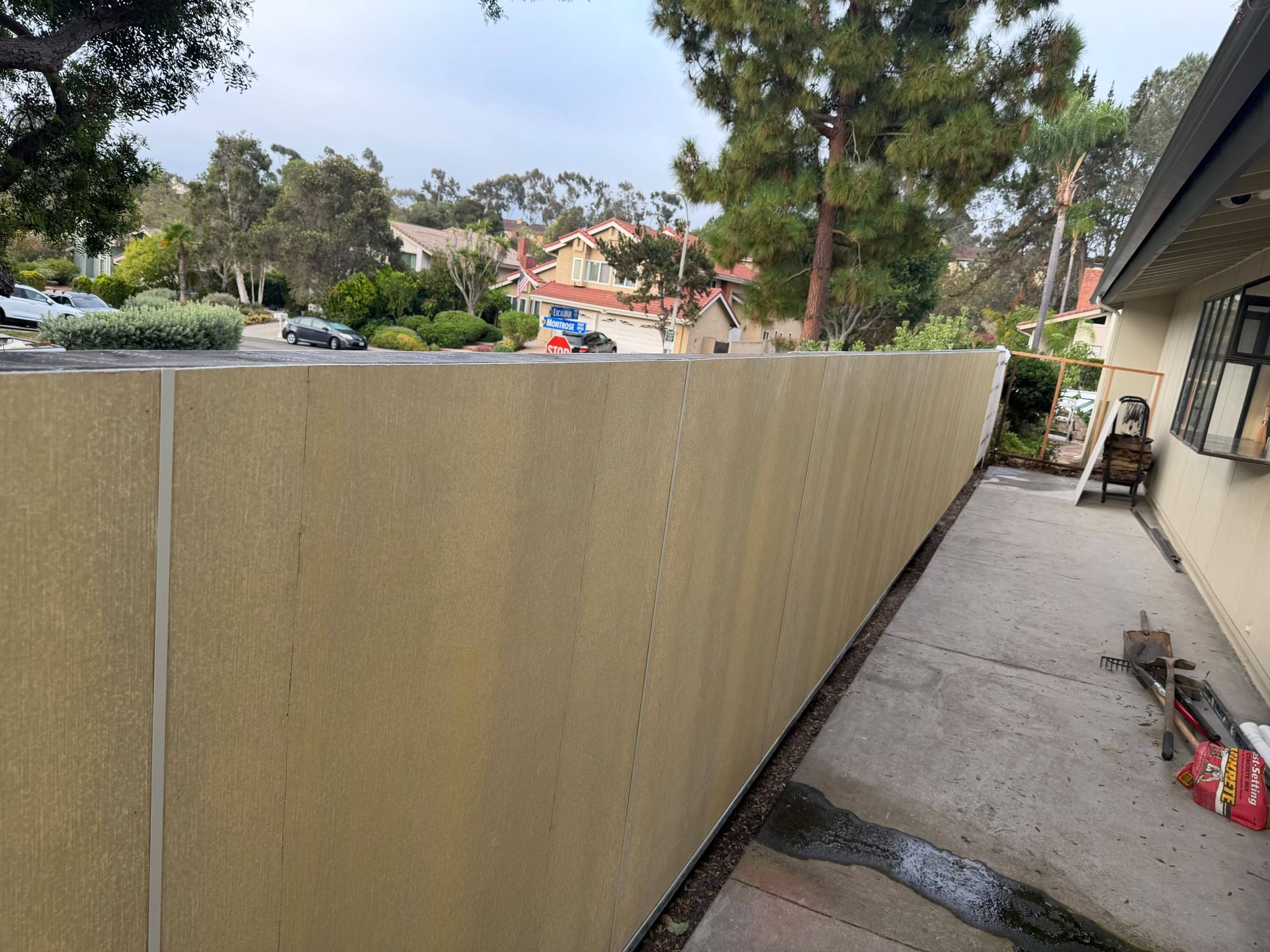 Fiber cement fence wall going up along a San Diego side yard