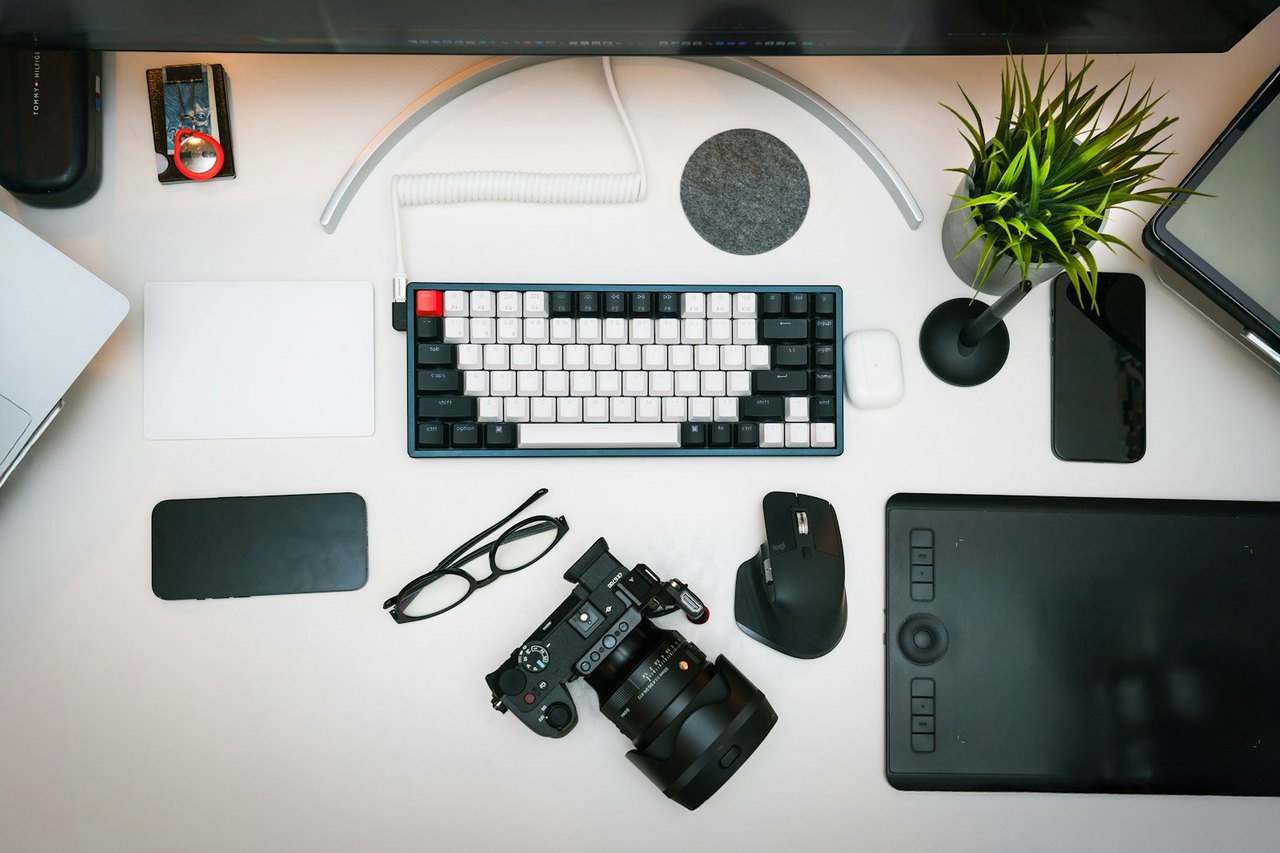 Aufgeräumter Schreibtisch von oben mit Tastatur, ergonomischer Maus, Grafiktablett und Kamera