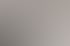 Eine lächelnde Frau sitzt an einem Schreibtisch vor einem Computerbildschirm in einem Büro.