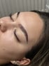 Nahaufnahme der linken Seite des Gesichts einer Frau mit geschlossenen Augen und perfekten Augenbrauen.