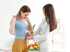 Nutritionist measures a young woman's waist, analyzing weight loss
