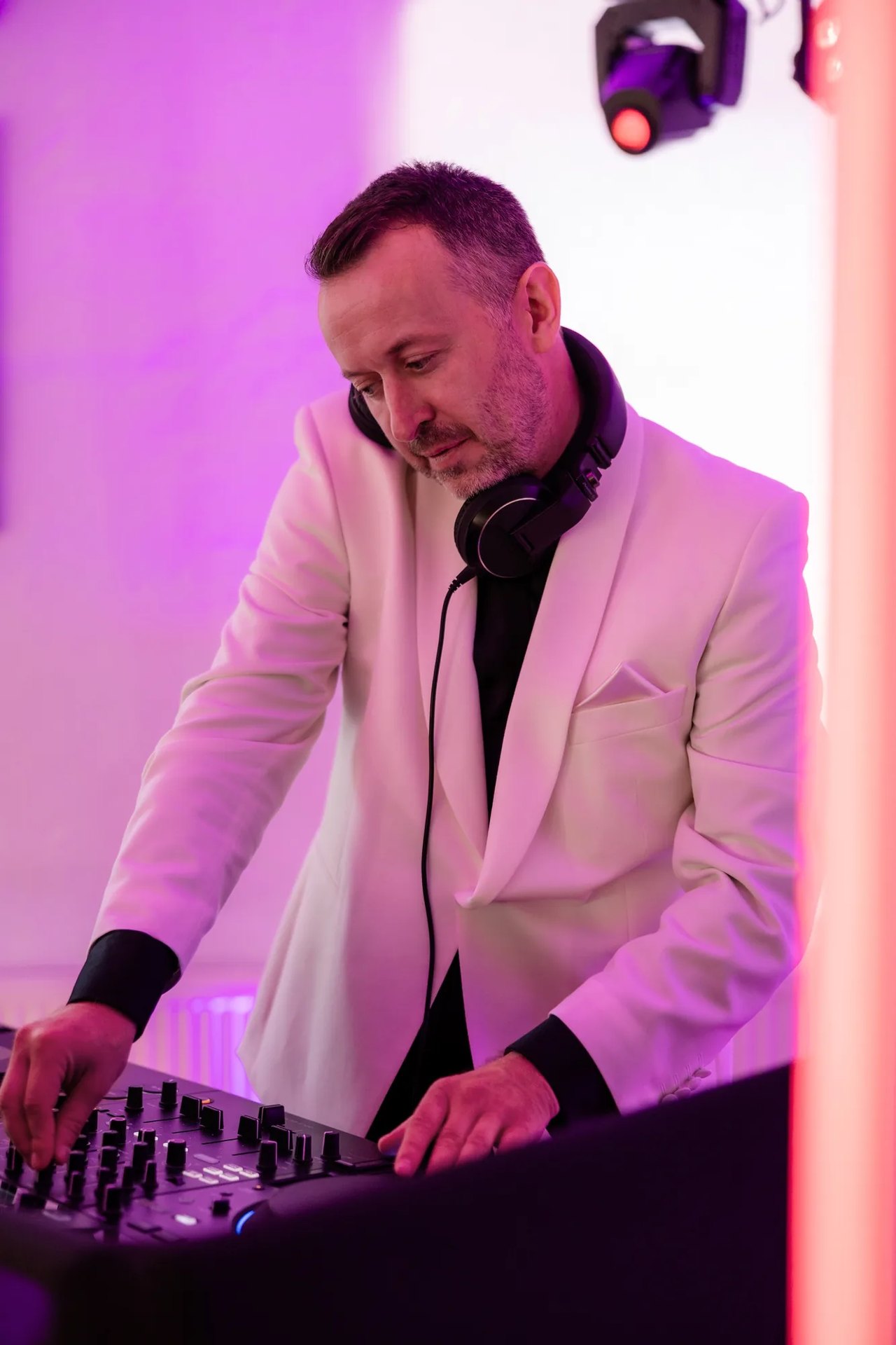 Hochzeits-DJ Michael Newell im weißen Dinnerjacket am DJ-Pult