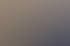 Ein lächelndes Ehepaar mittleren Alters mit Brille steht vor einer Steinmauer.
