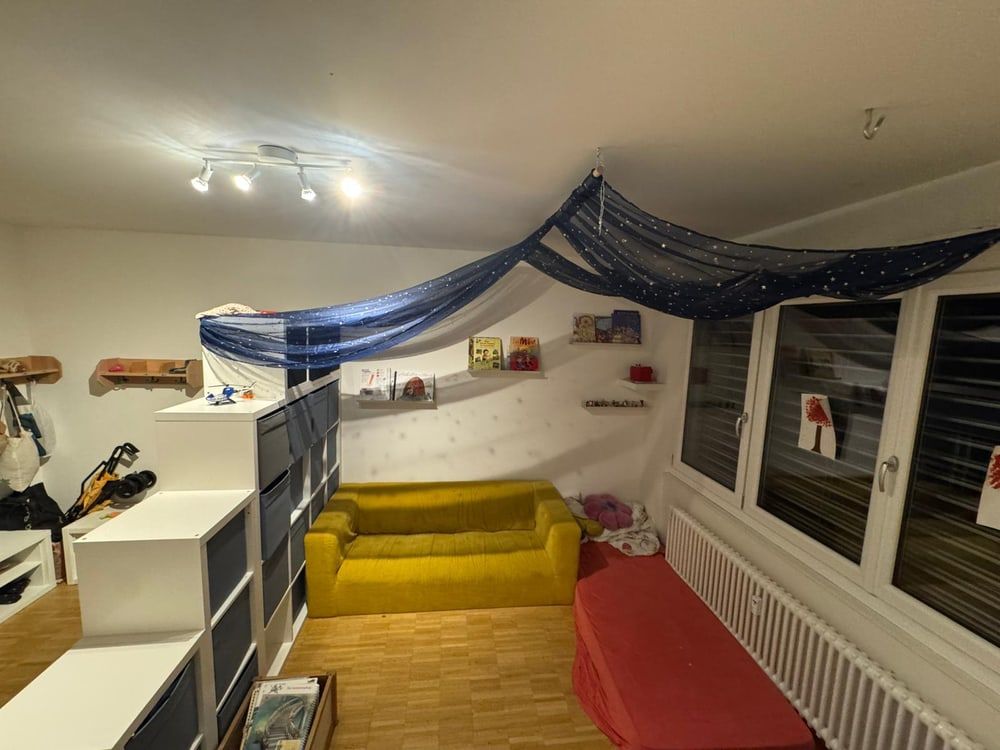 Kuschelbereich mit gelbem Sofa und Sternenhimmel-Tuch.