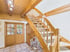 Innenraum mit Holztreppe, Holztür mit Glaseinsätzen, Holzbalkendecke und einem hellen Fliesenboden.