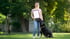 Eine Frau mit einem Berner Sennenhund hält eine Urkunde auf einer grünen Wiese.