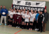Fußballteam SG Sieversdorf mit 13 jungen Frauen in Trikots, Trainer und Betreuern vor einem SG Sieversdorf Banner.