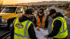 Towing Eastvale team planning the fastest roadside response route beside a branded tow truck on a highway at sunset