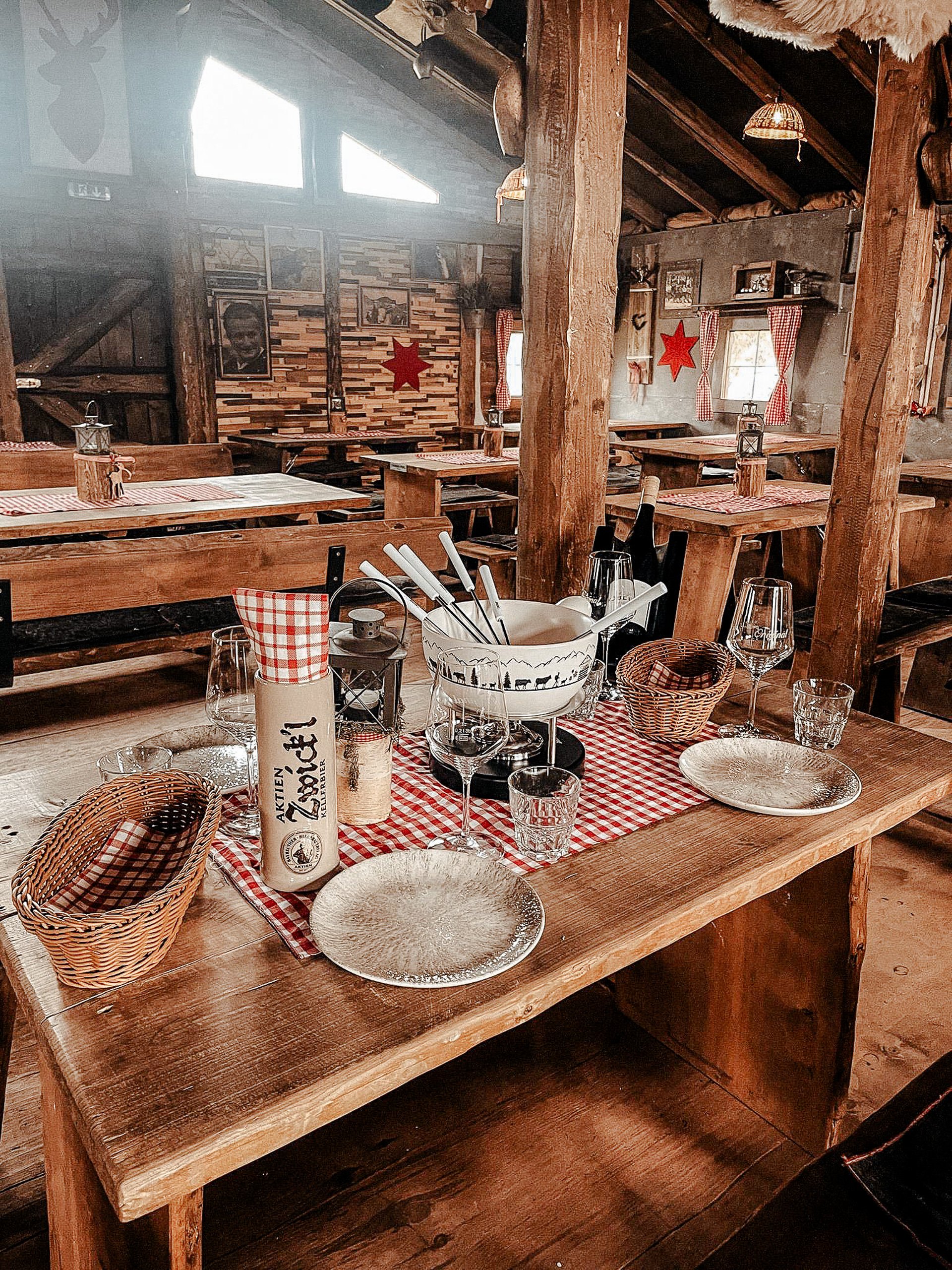 Holztische im Chalet, gedeckt mit rot-weiß kariertem Tuch