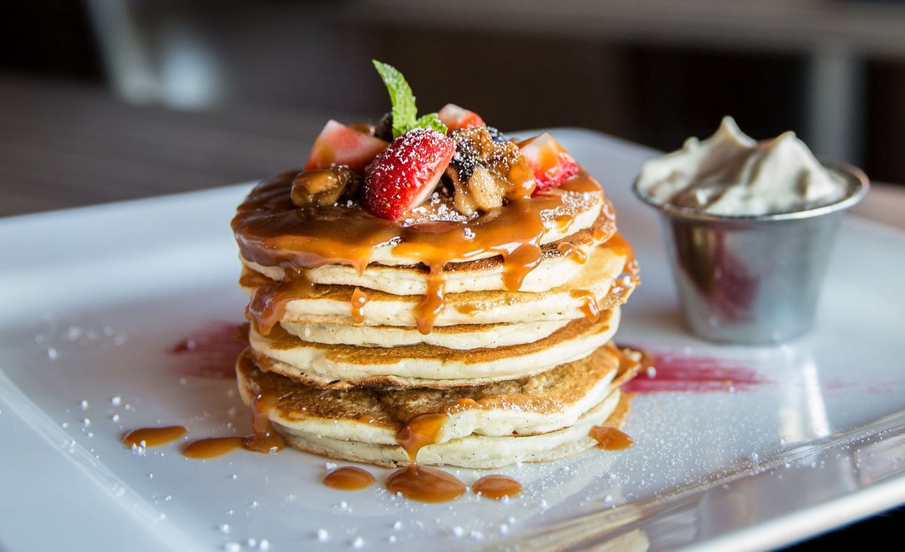 Frühstück mit Pfannkuchen, Beeren und Kaffee