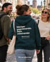 Drei Menschen lachen beim Gehen, in der Mitte ein petrolfarbener Wearmorrow® Hoodie mit der Rückenbotschaft Weniger gegeneinander Mehr miteinander