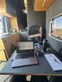 Mobiler Arbeitsplatz im Campervan mit Laptop, Schreibtisch und ergonomischem Sitz – flexibles Arbeiten unterwegs im durchdacht ausgebauten Reisemobil.