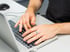 Hände tippen spät abends auf einer Laptop-Tastatur