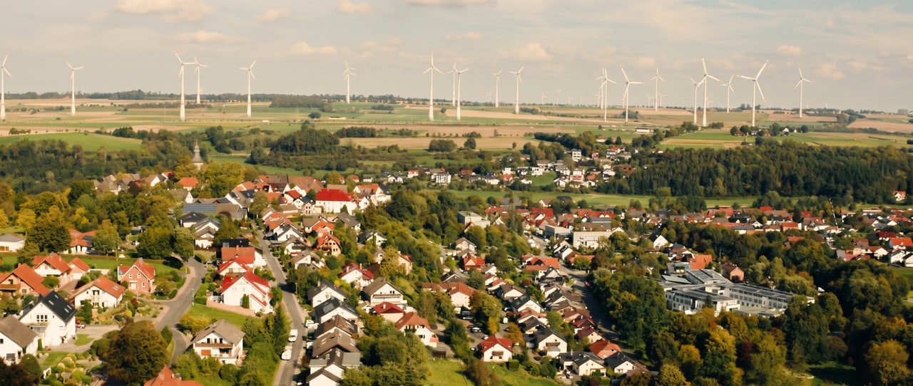 Luftaufnahme über die Dächer von Bad Wünnenberg und die Hochfläche mit Windrädern