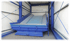 Blaue, geneigte Müllpresse in einer Wellblechhalle.