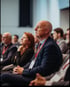 Zuhörer sitzen auf einer Konferenz und schauen aufmerksam nach vorne.