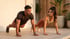 A man and woman in athletic wear perform high planks together on a patio during golden hour.