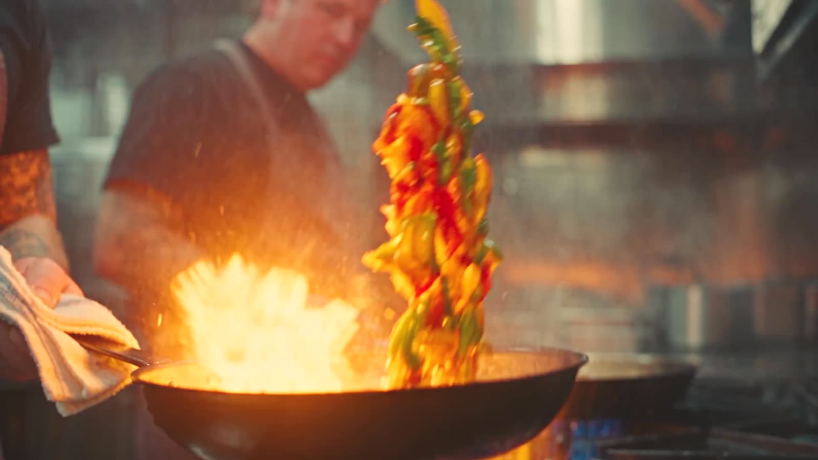 Freitagabend im vollen Restaurant: Flamme in der Pfanne, Teller am Pass, der Bondrucker läuft, ein Tisch stößt an.