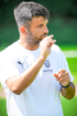 Mann mit Bart in weißem T-Shirt mit "BUFFON PRO GK ACADEMY" Logo spricht, Hand am Mund.