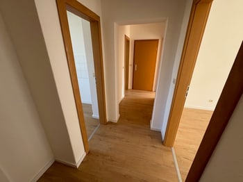 Heller Flur mit mehreren Zimmertüren und Laminatboden