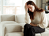 Woman with fibromyalgia rubs her forehead in chronic pain.