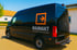 Schwarzer Lieferwagen mit orangefarbenem RAUMAKT-Logo und dem Text "WIR SCHAFFEN PLATZ FÜR NEUES".