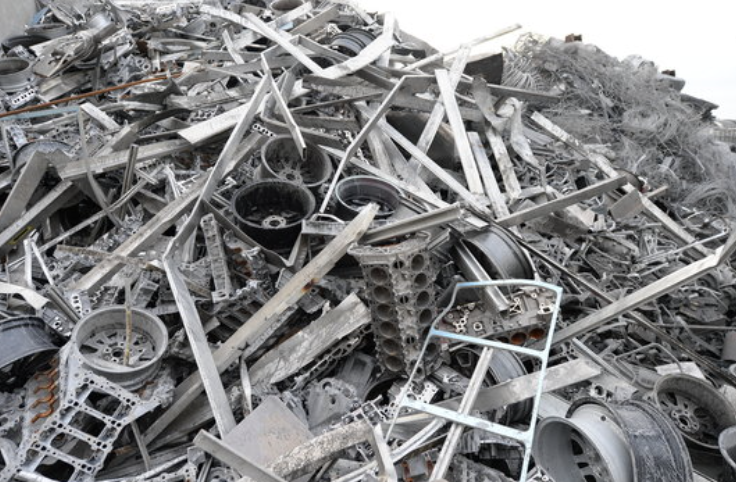 Ein großer Haufen Aluminiumschrott, darunter Felgen und Motorenteile, zur Wiederverwertung.