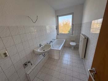 Gefliestes Badezimmer mit Wanne, Waschbecken und WC