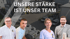 Vier lächelnde Mitarbeiter vor einem Firmengebäude mit Lieferwagen; Text: UNSERE STÄRKE IST UNSER TEAM